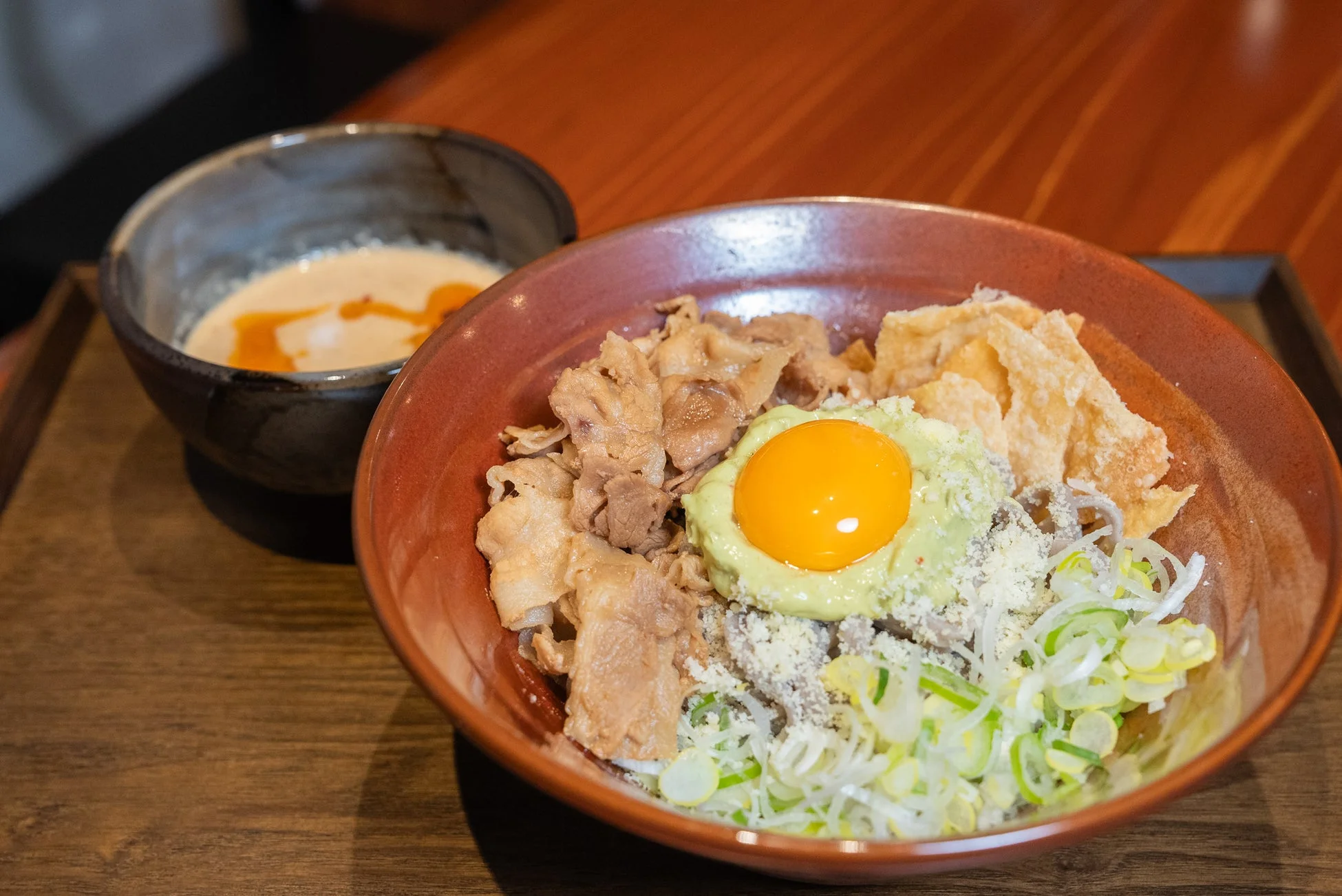 豚肉と卵黄が乗った麺料理