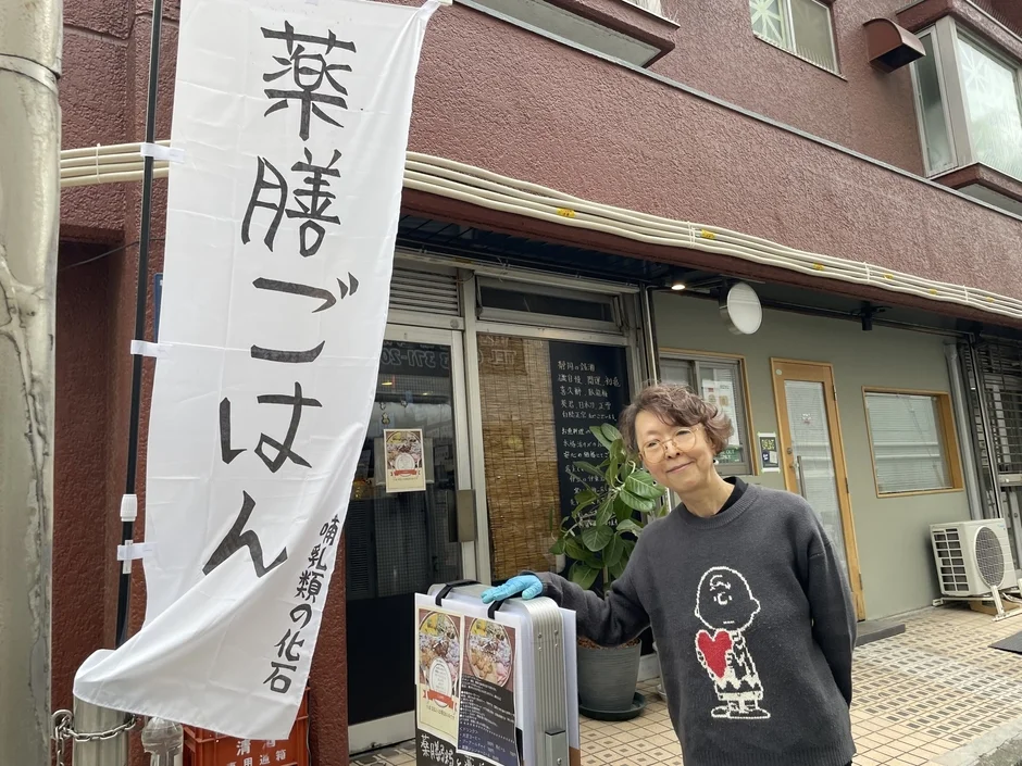 お店の前に立つ女性