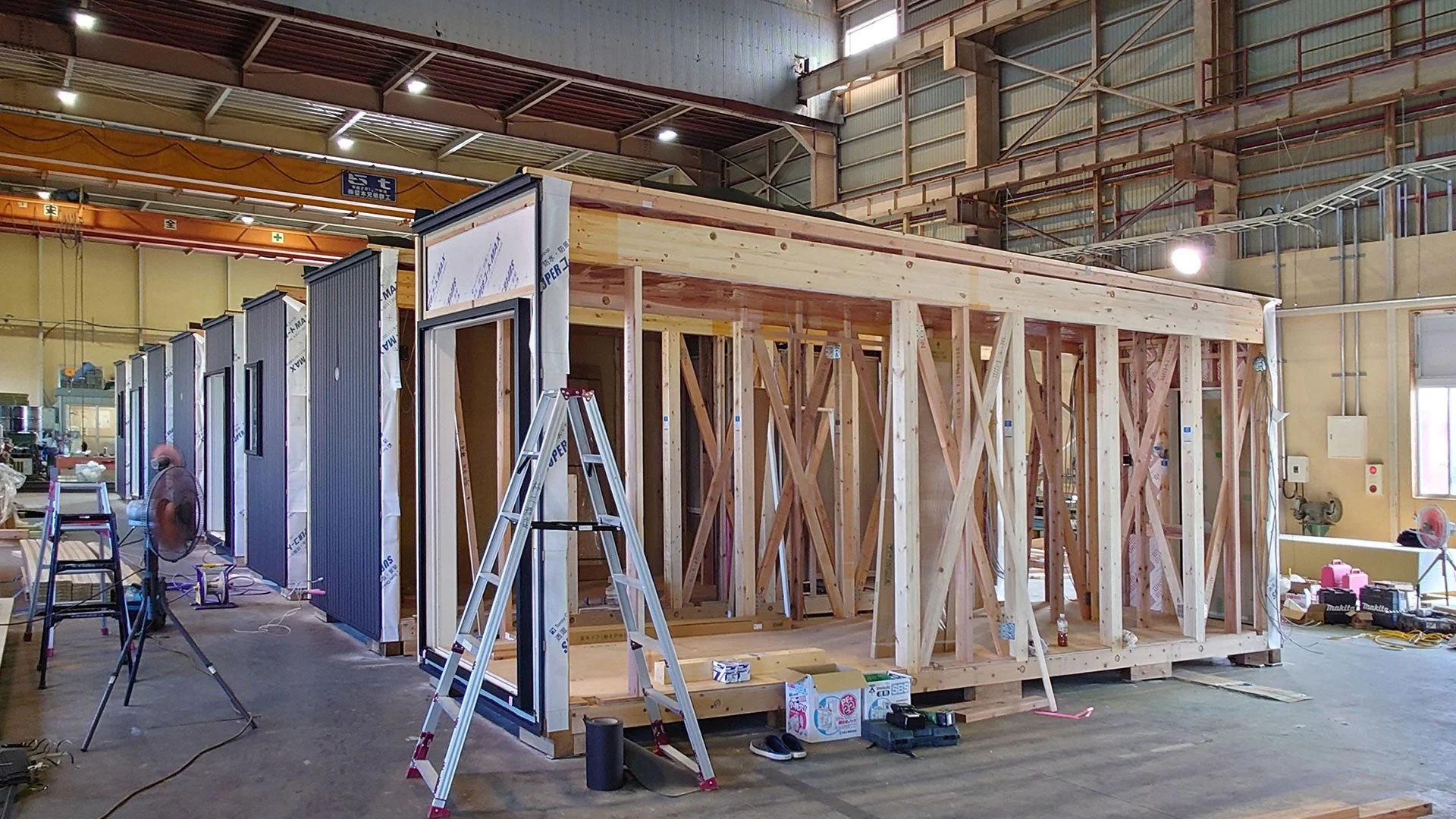 工場内でモジュール式の木造建築ユニットが建設されている様子です。