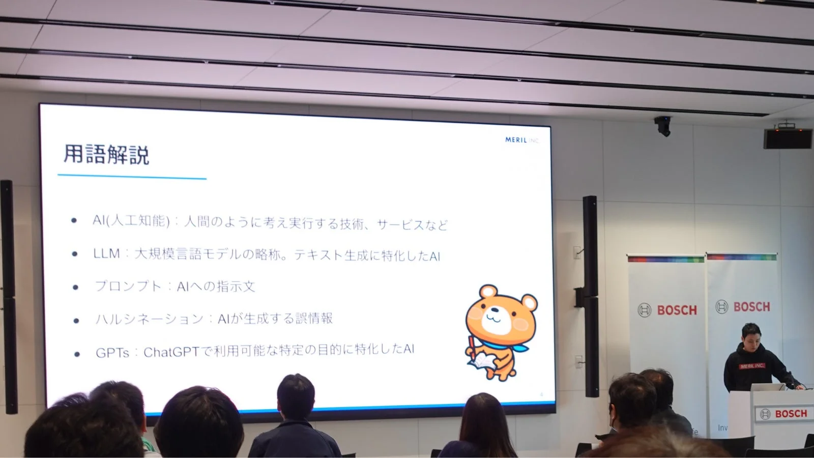 AI関連の用語解説スライドが映し出されたプレゼンテーションの様子