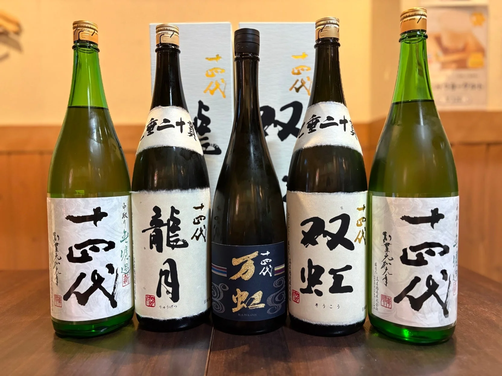「十四代」ブランドの日本酒ボトルが5本並べられた写真