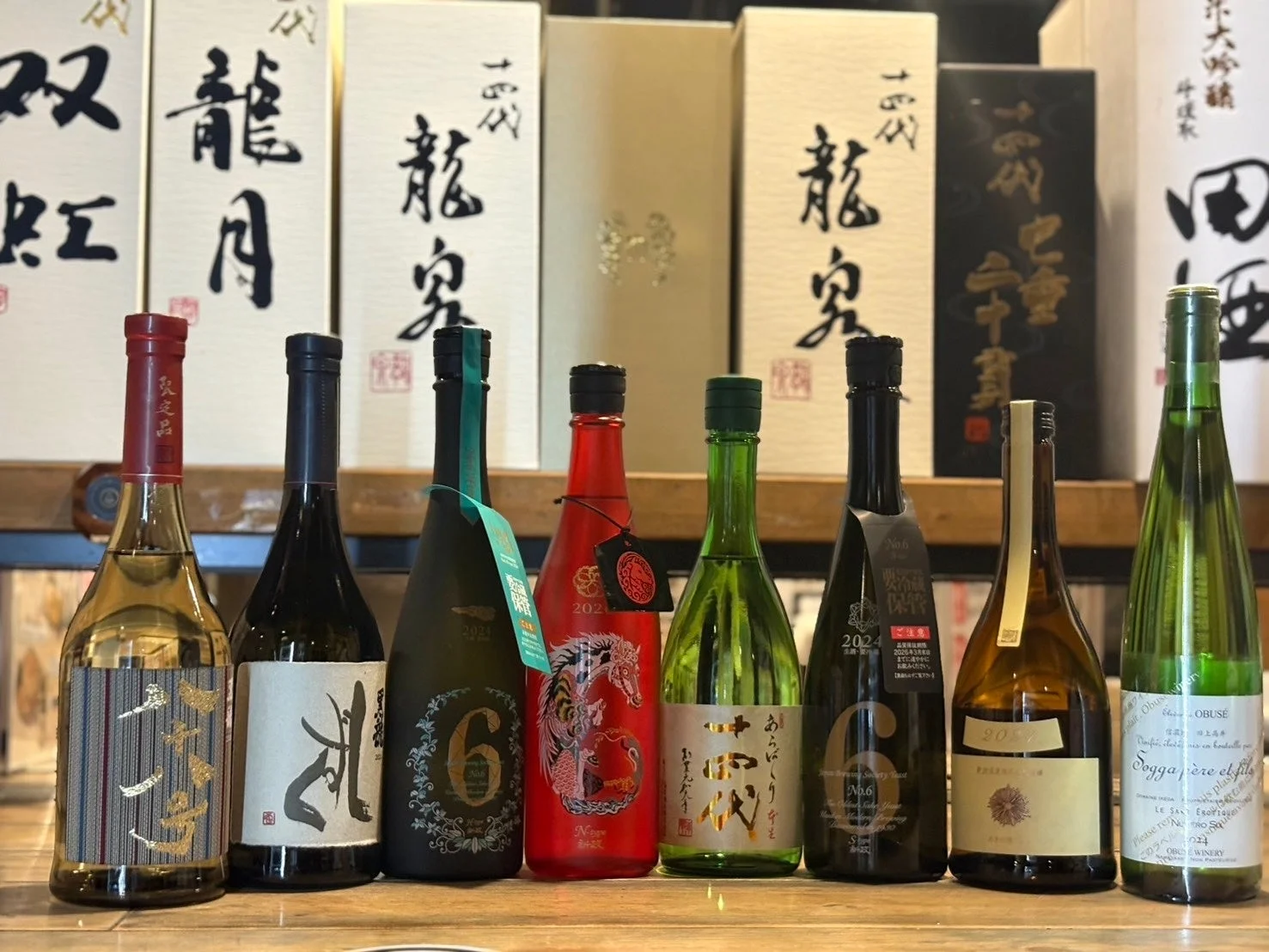 木製の棚に並べられた、様々な銘柄の日本酒やワインのボトル
