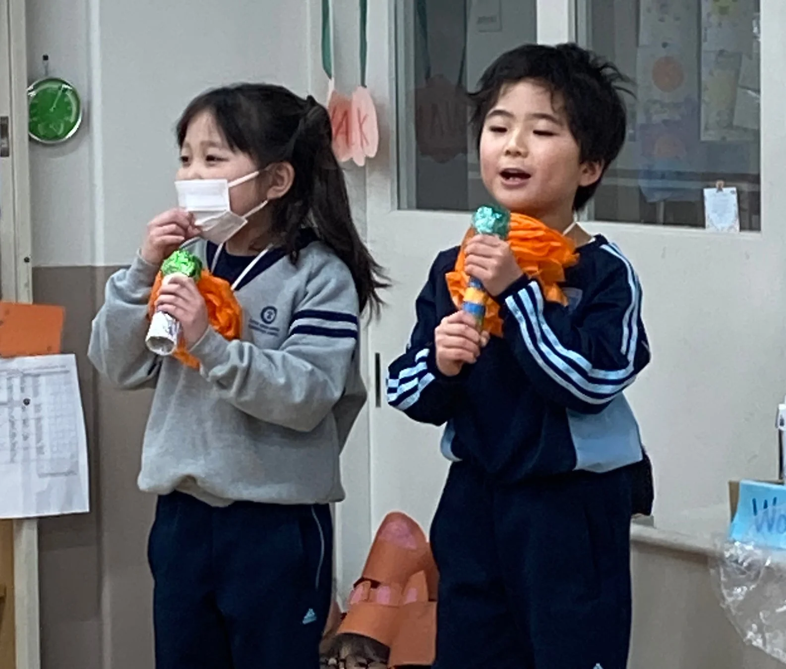 手作りのマイクを持って発表する小学生