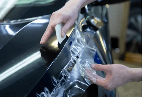 車のボンネットにフィルムを貼る作業の様子