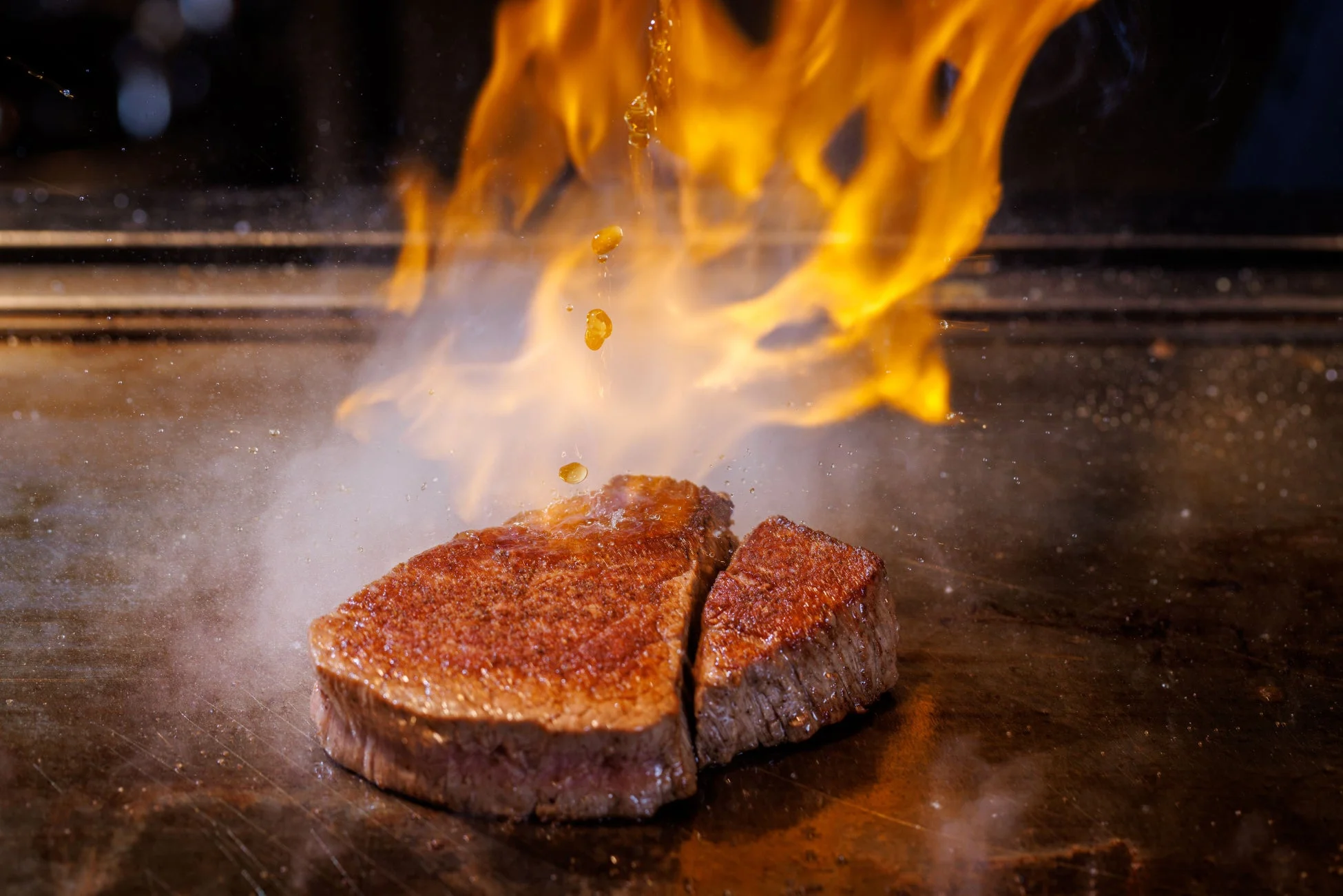 炎を上げて調理されるステーキ