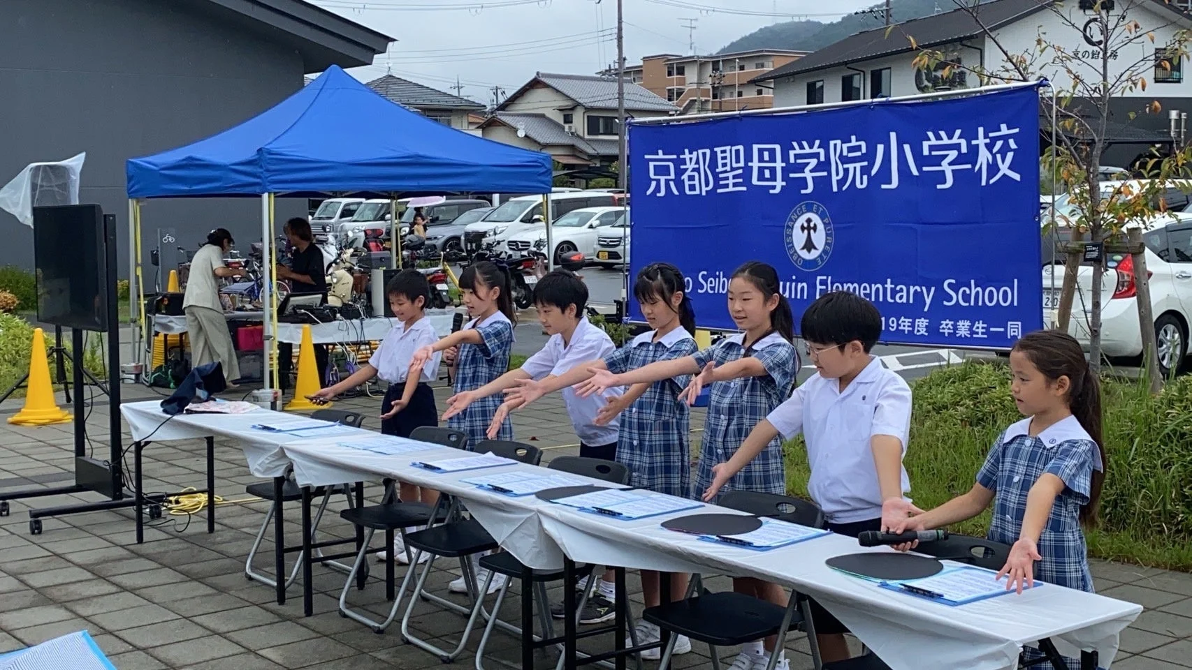屋外イベントでパフォーマンスを行う京都聖母学院小学校の生徒たち