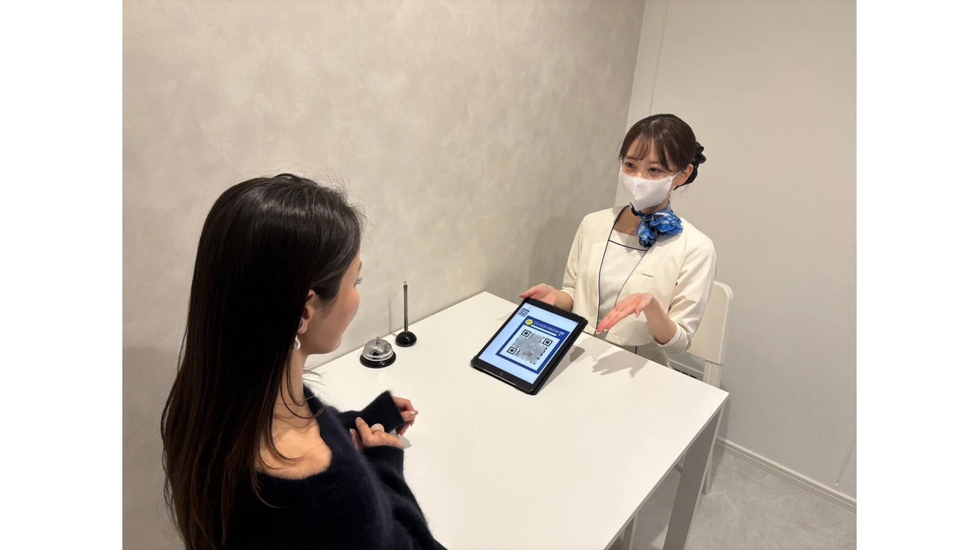 タブレットでQRコードを案内するスタッフの画像