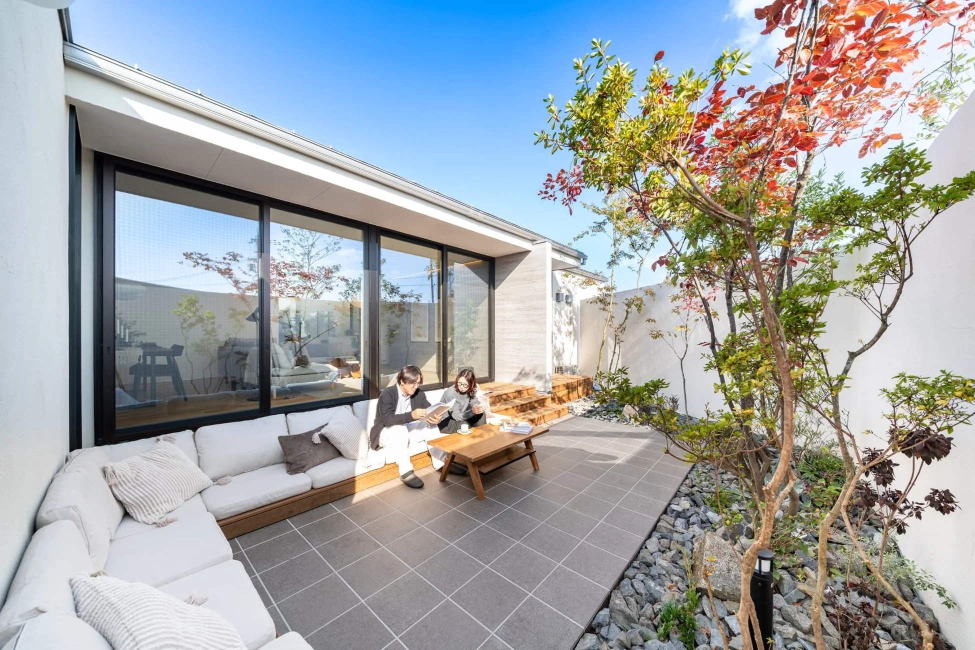 モダンな住宅の中庭で本を読む夫婦