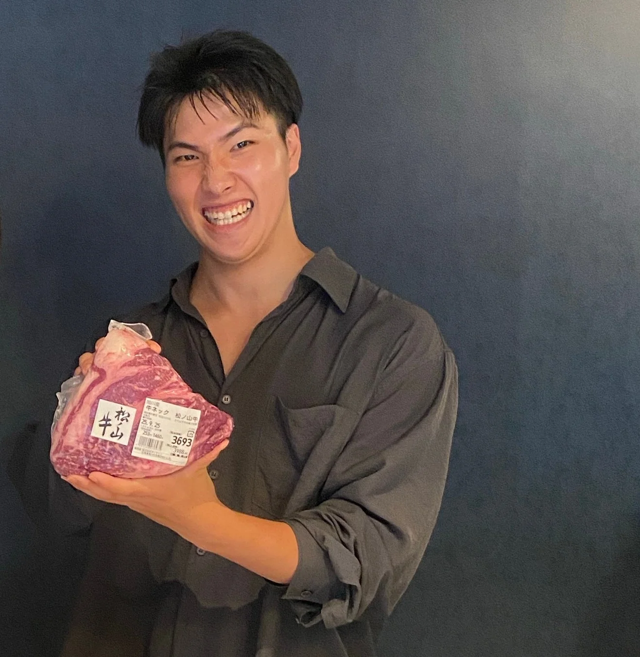 笑顔で肉の塊を持つ男性