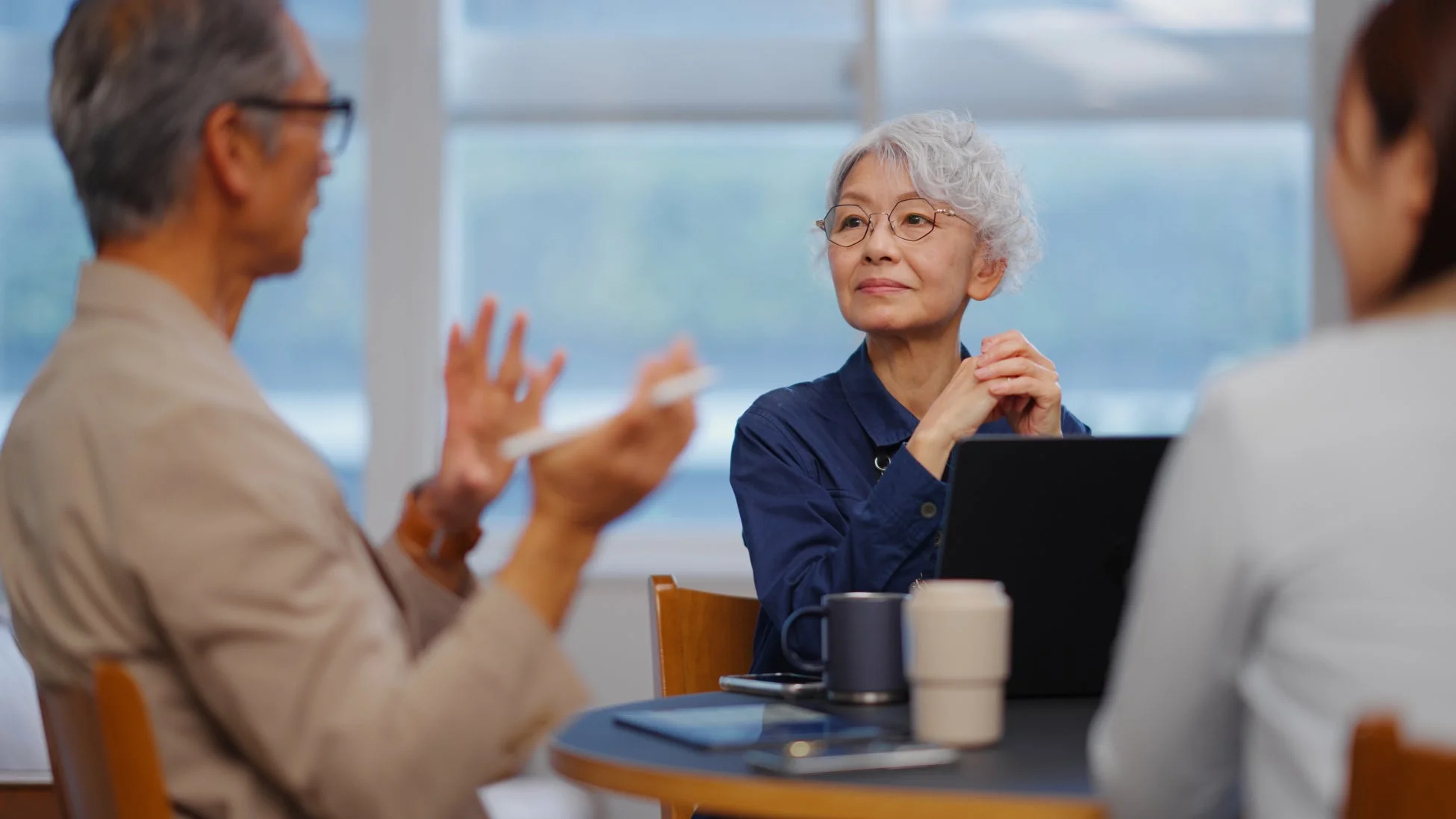 会議室で話し合う高齢の男女