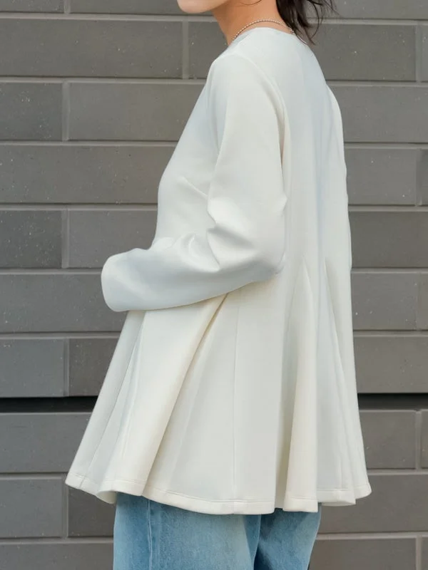 白いフレアトップスとジーンズを着用した人物の側面