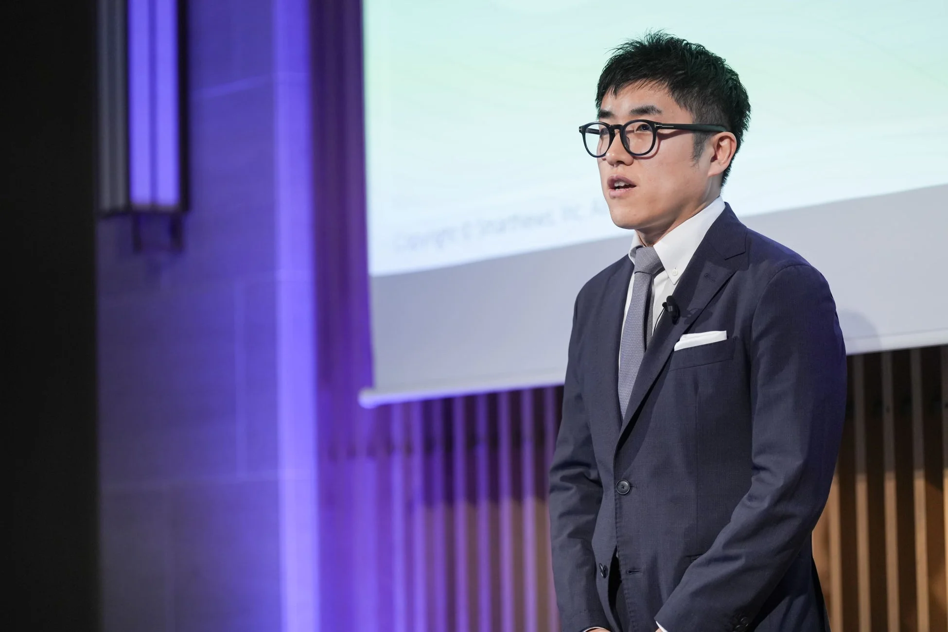 スーツ姿で登壇する浜本階生氏