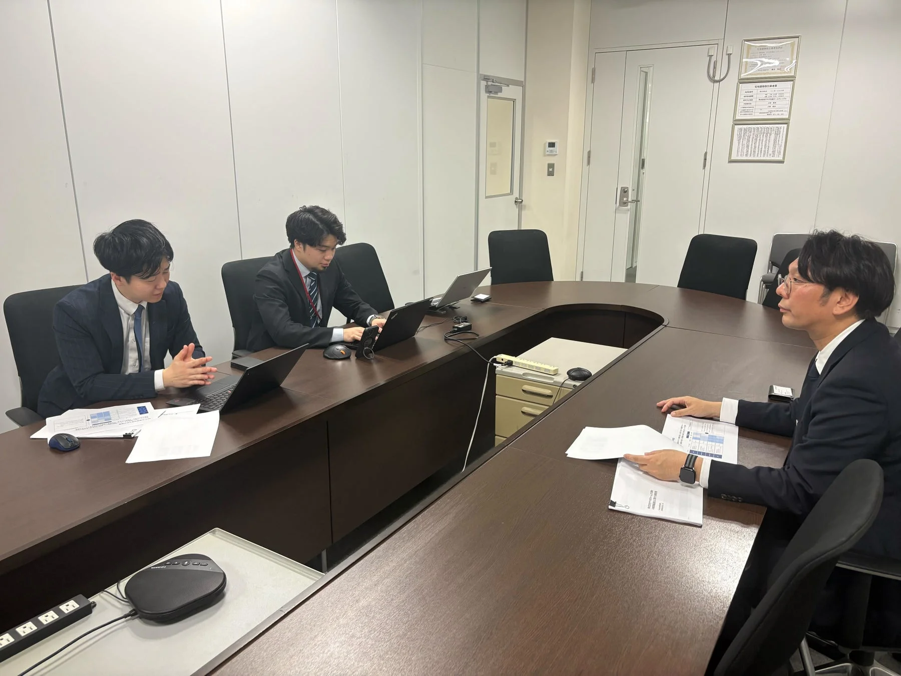 会議室での男性3人