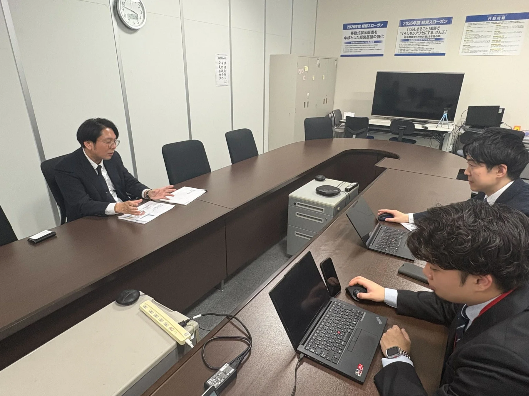会議室での男性3人