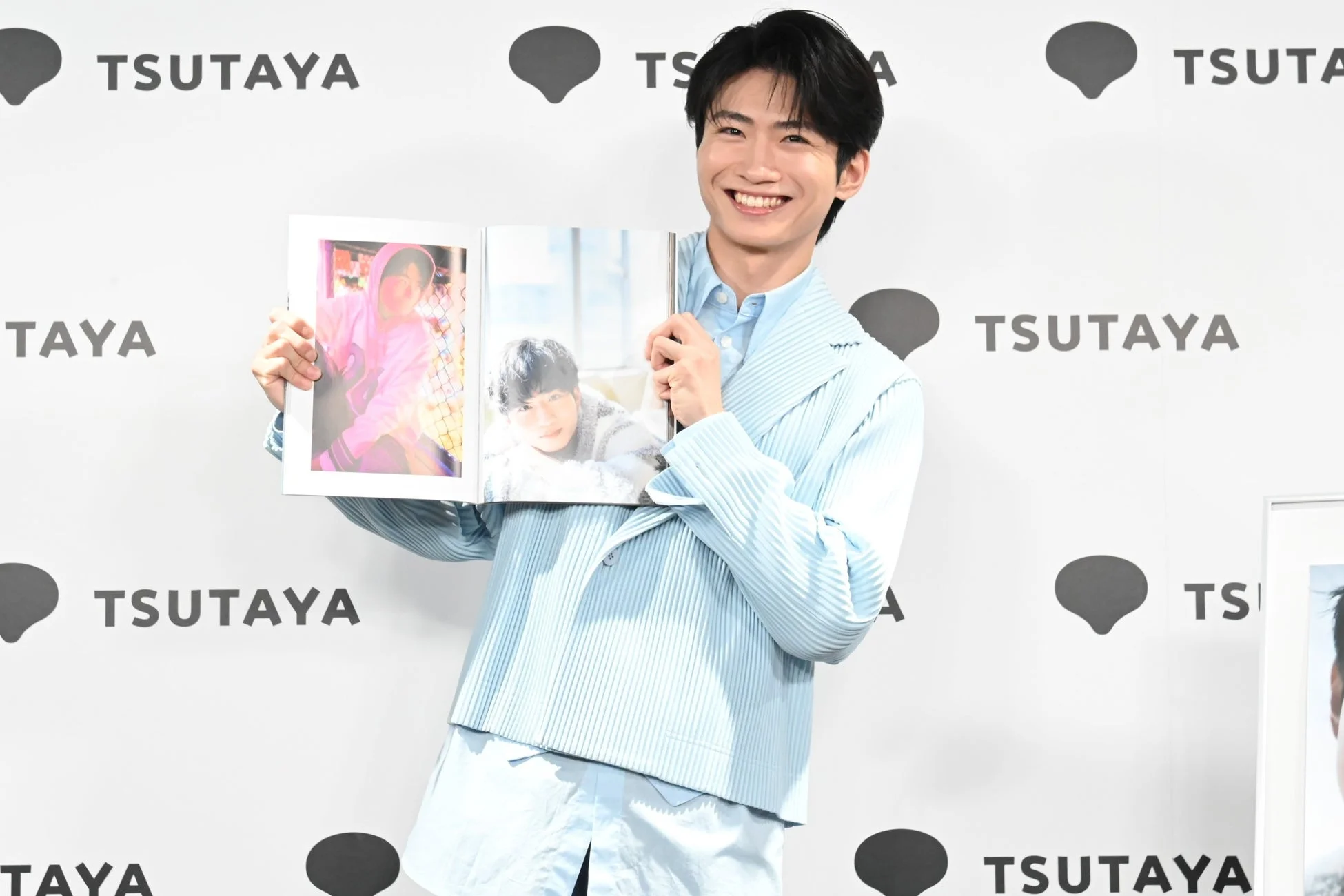 写真集を掲げる木村魁希さん