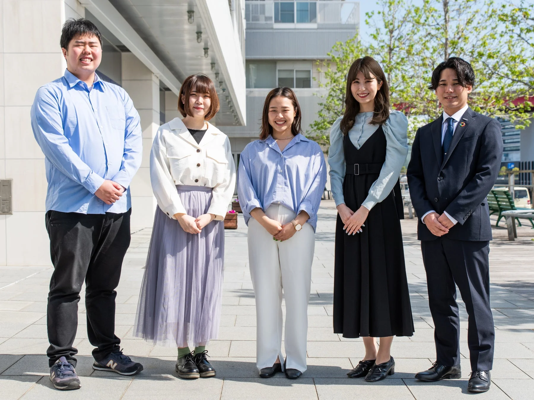 屋外で笑顔を見せる5人の若い日本人男女の集合写真