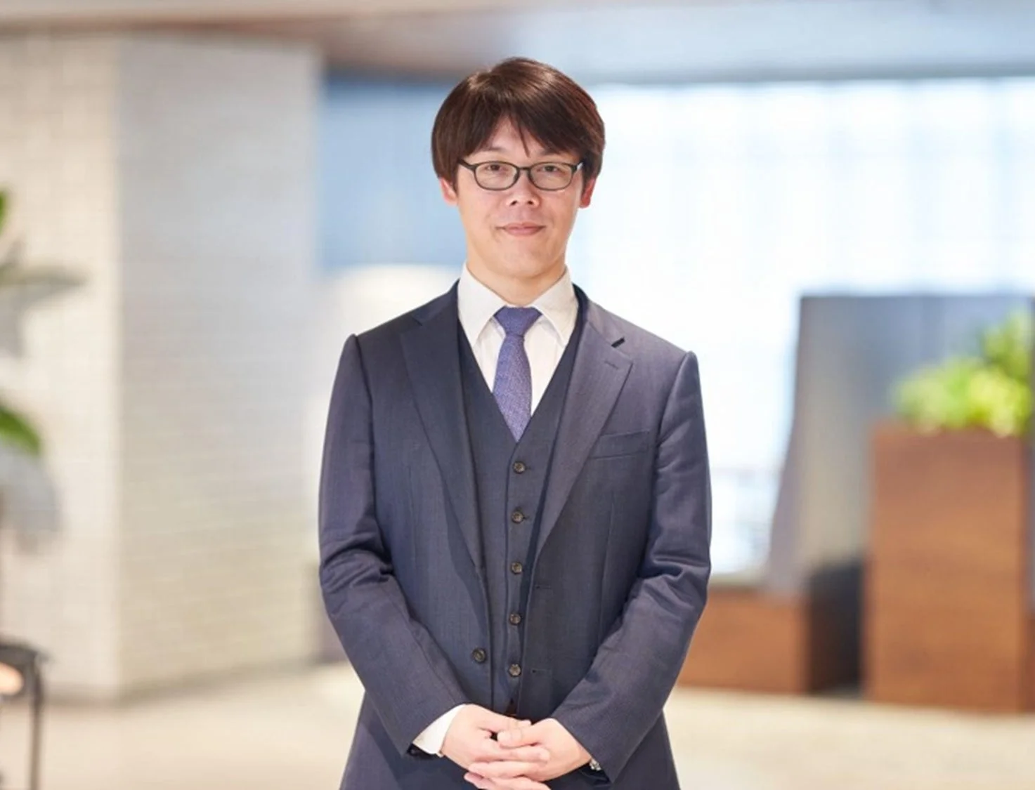 紺色のスーツと眼鏡をかけた池田克氏